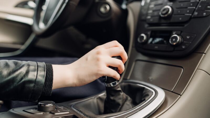 resting hand on stick shift shutterstock 627746645