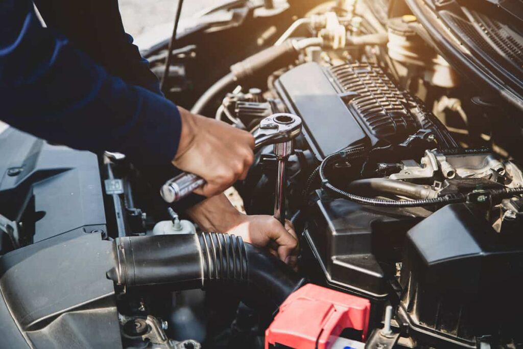 Auto mechanic hands using wrench to repair a car engine. concepts of car insurance support and services